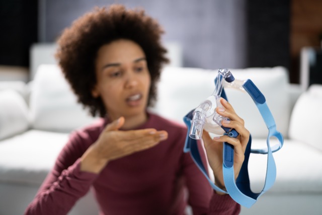 Shocked Young Woman Holding CPAP Machine